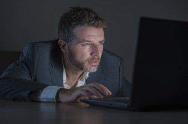 ticaret forex piyasası veya koyu arka plan üzerinde izole verileri analiz mali iş dizüstü bilgisayar kullanan gece geç saatlerde çalışan genç çekici ve adanmış işkolik girişimci adam