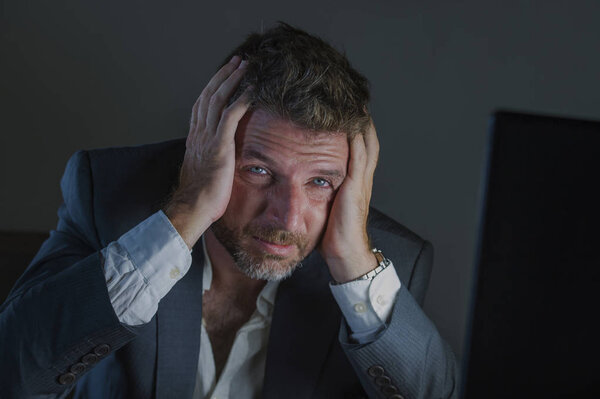 young desperate and stressed businessman working overtime at office laptop computer desk feeling anxious and overwhelmed suffering depression problem and anxiety crisis in business problem