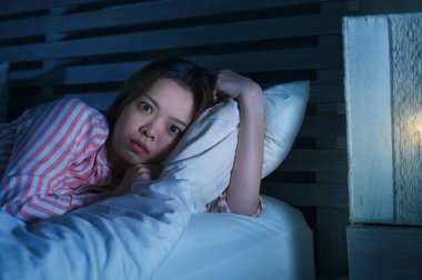 yatak gece uyanık düşünceli uykusuzluk uyku bozukluğu duygu yorgun acı ve kadın depresyon kavramı içinde endişeli bakarak yalan genç güzel üzgün ve depresyonda Asyalı Çinli kız