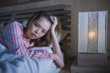 yatak gece uyanık düşünceli uykusuzluk uyku bozukluğu duygu yorgun acı ve kadın depresyon kavramı içinde endişeli bakarak yalan genç güzel üzgün ve depresyonda Asyalı Çinli kız