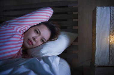 yatak gece uyanık düşünceli uykusuzluk uyku bozukluğu duygu yorgun acı ve kadın depresyon kavramı içinde endişeli bakarak yalan genç güzel üzgün ve depresyonda Asyalı Çinli kız