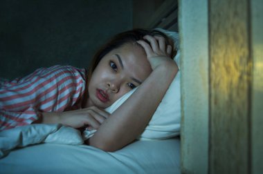 yatak gece uyanık düşünceli uykusuzluk uyku bozukluğu duygu yorgun acı ve kadın depresyon kavramı içinde endişeli bakarak yalan genç güzel üzgün ve depresyonda Asyalı Çinli kız