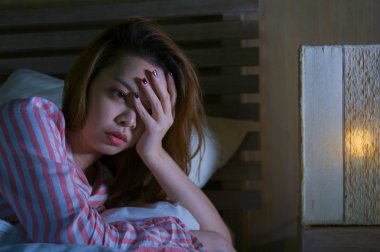 yatak gece uyanık düşünceli uykusuzluk uyku bozukluğu duygu yorgun acı ve kadın depresyon kavramı içinde endişeli bakarak yalan genç güzel üzgün ve depresyonda Asyalı Koreli kız