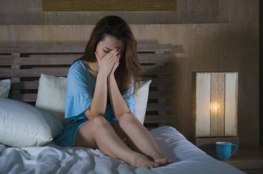depresyon sorunu ve anksiyete krizi acısı ya da siber kavramı zorbalık acı kız üzgün hissi geceleri yatakta ağlayan genç güzel ve depresif Asyalı Koreli kadın