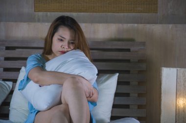 depresyon sorunu ve anksiyete krizi acısı ya da siber kavramı zorbalık acı kız üzgün hissi geceleri yatakta ağlayan genç güzel ve depresif Asyalı Koreli kadın