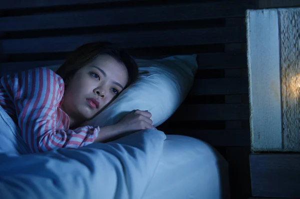 年轻美丽的悲伤和郁闷的亚洲中国女孩躺在床上深夜醒着看着想失眠睡眠障碍感到疲惫和担心在女人抑郁的概念 — 图库照片