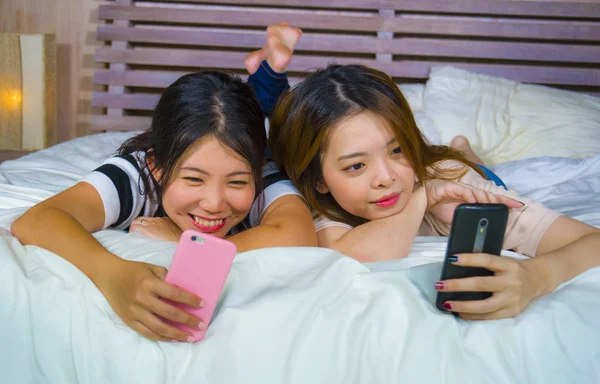 아시아 이야기 침실에서 여성의 우정에 침대에 전화와 인터넷 미디어 — 스톡 사진