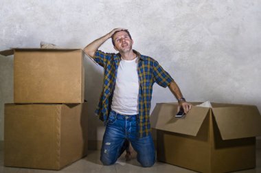 mutlu ve heyecanlı genç adam eve katta yalnız yeni daire veya ev neşeli kutluyor emlak sahibi durumu gülümseyen hareket karton kutular açma zevk