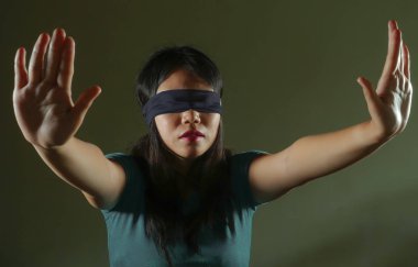 Genç korkmuş ve Asyalı Genç kız kayıp ve sinirli ve dramatik stüdyo ışık altında koyu arka plan üzerinde tehlikeli internet viral meydan okuma izole çalmaya karışık Korece gözü kapalı