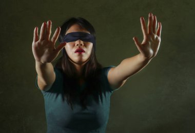 Genç korkmuş ve Asyalı Genç kız kayıp ve sinirli ve dramatik stüdyo ışık altında koyu arka plan üzerinde tehlikeli internet viral meydan okuma izole oyun karıştı Çin gözü kapalı