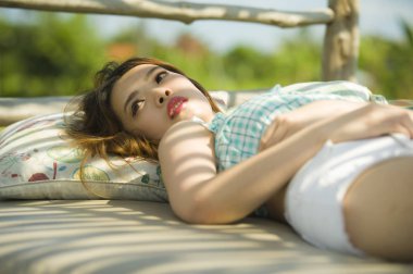 Genç güzel ve seksi Asyalı kadın tatil resort Bahçe Yatak güneşlenme bronzlaşma sahip rahat yalan rahat ve yaz tatil ve güzellik kavramı soğutulmuş Korece 