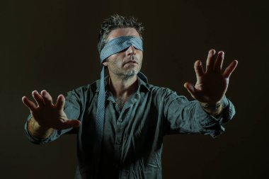kravat oynarken Internet eğilim tehlikeli viral meydan okuma ile şüpheli hareket kör gözlü gözü kapalı genç kayıp ve şaşkın adam koyu arka plan üzerinde izole sezgi rehberliğinde