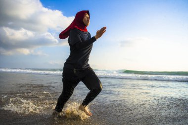 çalışan ve geleneksel Arap spor kıyafetlerle fitness egzersiz ve kilo kaybı kavramında sahilde koşu Islam türban Başörtüsü Müslüman kadında genç sağlıklı ve aktif atlet