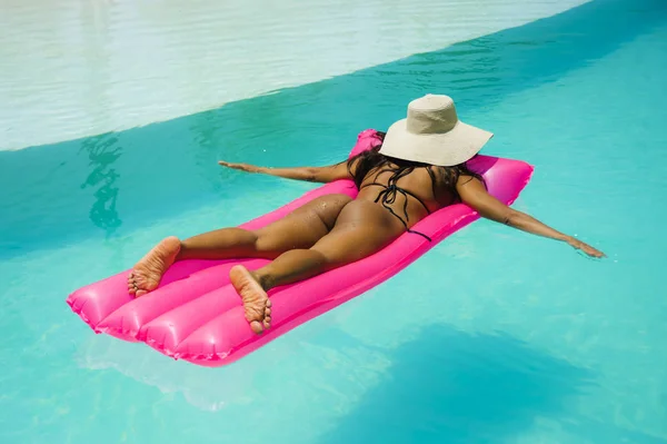 年轻的有吸引力和性感的女人比基尼躺在充气气床放松和日光浴在游泳池在天堂热带度假村寒冷和快乐的假期旅行和流浪汉艰苦的生活方式 — 图库照片