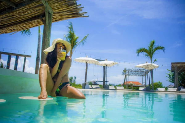 若いですセクシーと魅力的なエキゾチックなアジアの女性でビキニと夏の帽子飲みジュースでパラダイススイミングプールリゾートバー笑顔幸せな熱帯島での豪華な休日の旅行を楽しんで — ストック写真