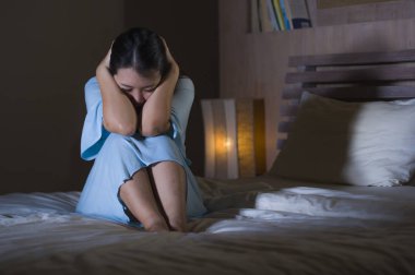 Genç güzel ve hüzünlü Asyalı Çinli kadın yatakta depresyon kriz ve uykusuzluk duygu ağrı ve kırık kalp acı geceleri uyanık çaresiz ağlama dramatik portresi