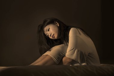 Genç güzel ve hüzünlü Asyalı Japon kadın yatakta depresyon kriz ve uykusuzluk duygu ağrı ve kırık kalp acı geceleri uyanık çaresiz ağlama dramatik portresi