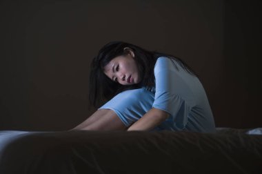 Genç güzel ve üzgün Asyalı Koreli kadın yatakta depresyon kriz ve uykusuzluk duygu ağrı ve kırık kalp acı geceleri uyanık çaresiz ağlama dramatik portresi