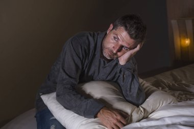 genç çekici üzgün ve depresyonda adam boğulmuş ve dramatik acı duygu kavramı ışığında üzerinde gece geç saatlerde vurguladı anksiyete krizi ve depresyon sorun duygu acı yatakta
