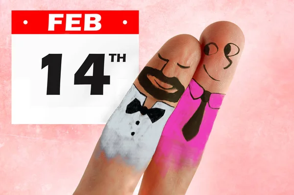 two fingers with cartoon man face painted as happy and free homosexual couple in love celebrating Valentines day in gay rights freedom and respect concept isolated on pink background