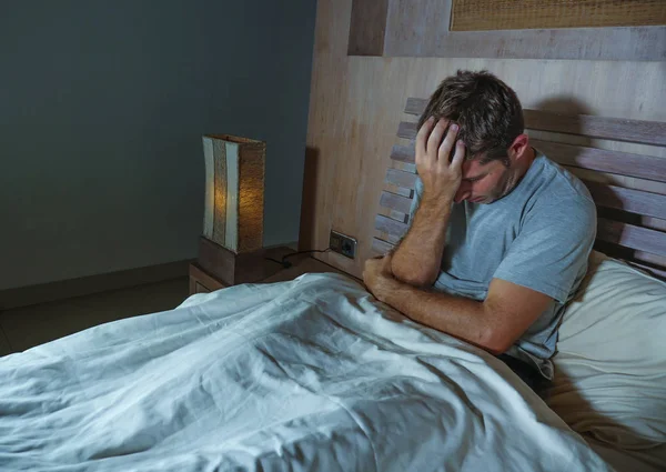 Λυπημένος και καταθλιπτικός άγρυπνες νεαρός ξαπλωμένος στο κρεβάτι ανήσυχος και προσεκτική στο σπίτι υπνοδωμάτιο πάσχει κατάθλιψη πρόβλημα αίσθημα αδιαθεσίας και απελπισμένος σπασμένη καρδιά — Φωτογραφία Αρχείου
