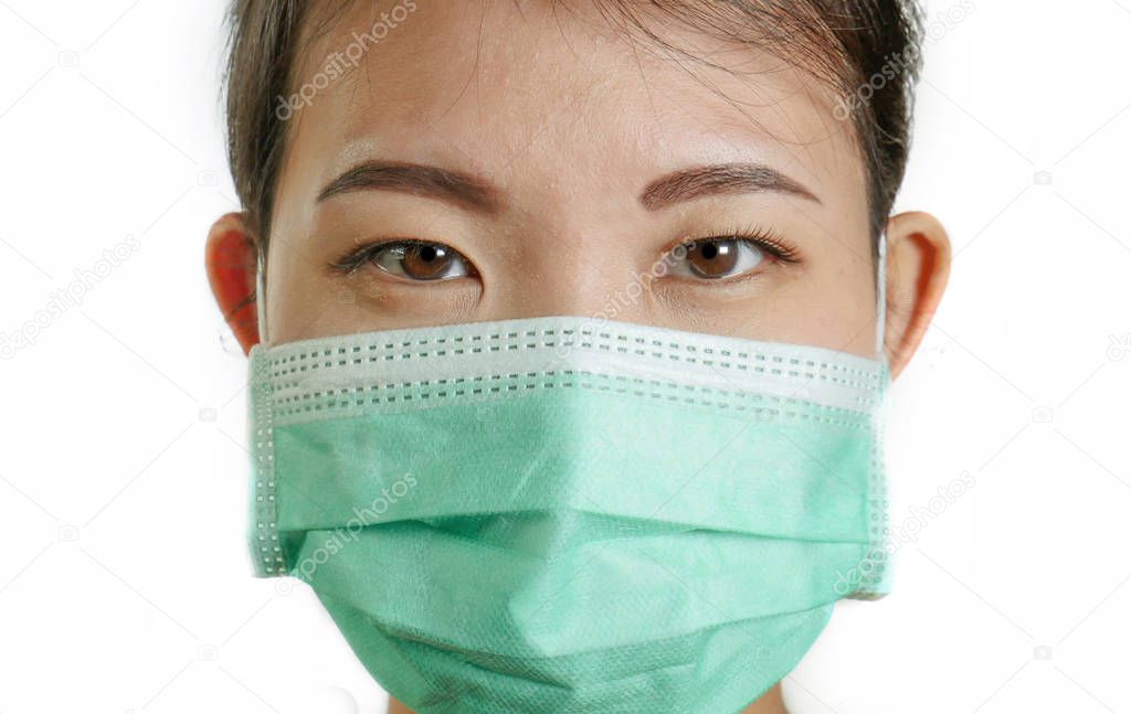 close up portrait of young beautiful and attractive Asian Korean woman wearing blue protective face mask looking to the camera isolated on white background in pollution and protection concept