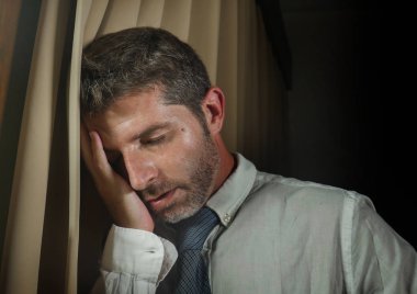 kravat duygu depresyon ve pencere perdeleri üzerinde geç gece evde ofis eğilerek iş sorunu hayal kırıklığına uğramış genç üzgün ve depresyonda işadamı portresi dramatik yaşam tarzı