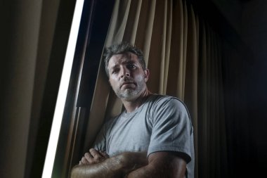 dramatik ışık kapalı ev Oda penceresinden dalgın ve düşünceli arıyorum, Genç üzgün ve depresyonda çekici bir adam portresi kırık kalp depresyon sorun acı acı kayıp.