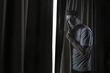 dramatik ışık kapalı portre çekici genç üzgün ve depresyonda adam ev oda pencere düşünceli ve dalgın depresyon sorunu ve anksiyete krizi acı acı içinde aramak