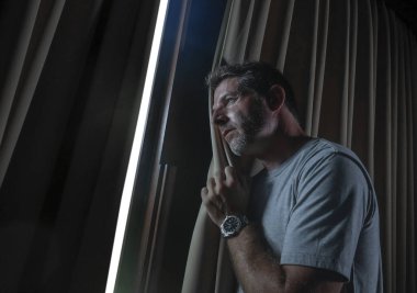 dramatik ışık kapalı ev Oda penceresinden dalgın ve düşünceli arıyorum, Genç üzgün ve depresyonda çekici bir adam portresi kırık kalp depresyon sorun acı acı kayıp.