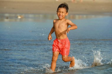 5 yaşında tatlı ve mutlu çocuk heyecanlı ve neşeli seyahat tatil ve turistik eğlence kavramı içinde çalışan tatil zevk denizde ücretsiz oynamak plaj eğleniyor