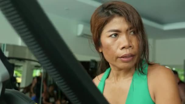 年轻的决心和运动的亚洲印尼运动女子训练健身努力在健身房做椭圆机锻炼在健康的生活方式概念的脸拍摄 — 图库视频影像
