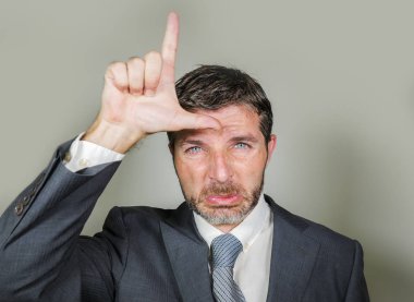 ağlayan 30'lu veya 40'lı tıraşsız üzgün ve utanç işadamı kaybeden işaretiyle el ve parmaklarını alnına komik depresif ifade başarısız kariyer kavramı ile yapıyor