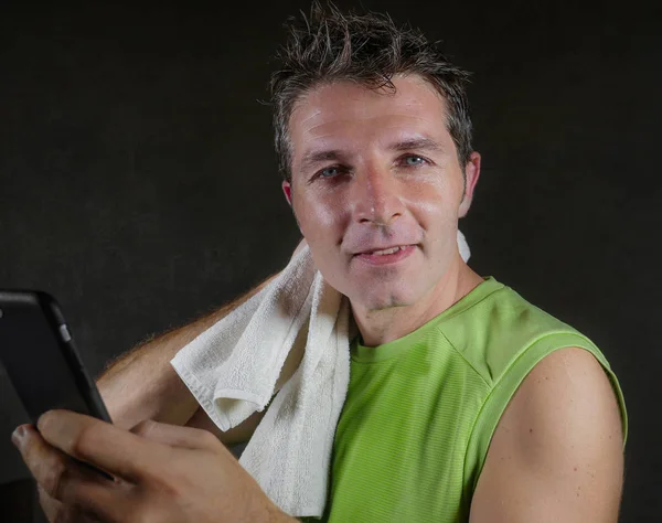 年轻快乐和有吸引力的30或40出汗的男人微笑愉快后 健身俱乐部训练锻炼感觉满意检查性能数据上的手机应用程序 而在健身房锻炼 — 图库照片