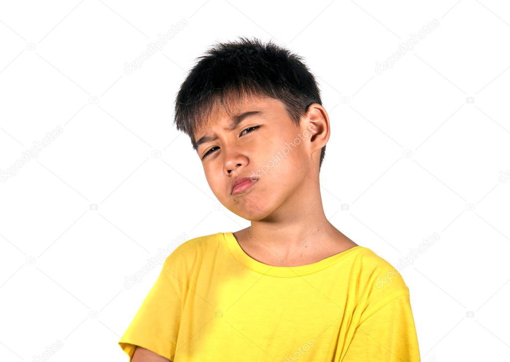 7 or 8 years old kid in serious and cool face expression posing as a badass playing the bully isolated on white background wearing yellow tshirt in interesting child face expression