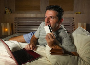 yatan yatak yatak satın alma veya kullanma online bankacılık genç çekici ve rahat adam evde elektronik iş ve ticaret kavramı ödeme için kredi kartı