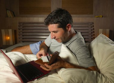 yatan yatak yatak satın alma veya kullanma online bankacılık genç çekici ve rahat adam evde elektronik iş ve ticaret kavramı ödeme için kredi kartı