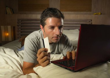 yatan yatak yatak satın alma veya kullanma online bankacılık genç çekici ve rahat adam evde elektronik iş ve ticaret kavramı ödeme için kredi kartı