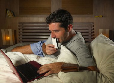 yatan yatak yatak satın alma veya kullanma online bankacılık genç çekici ve rahat adam evde elektronik iş ve ticaret kavramı ödeme için kredi kartı