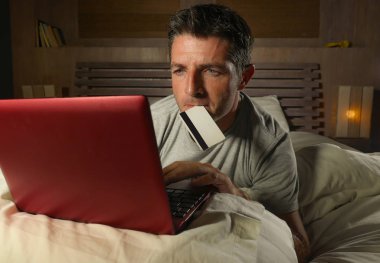 yatan yatak yatak satın alma veya kullanma online bankacılık genç çekici ve rahat adam evde elektronik iş ve ticaret kavramı ödeme için kredi kartı