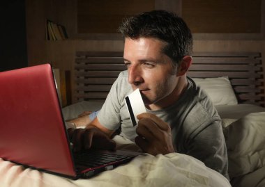 yatan yatak yatak satın alma veya kullanma online bankacılık genç çekici ve rahat adam evde elektronik iş ve ticaret kavramı ödeme için kredi kartı