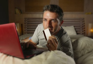 yatan yatak yatak satın alma veya kullanma online bankacılık genç çekici ve rahat adam evde elektronik iş ve ticaret kavramı ödeme için kredi kartı