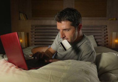 yatan yatak yatak satın alma veya kullanma online bankacılık genç çekici ve rahat adam evde elektronik iş ve ticaret kavramı ödeme için kredi kartı