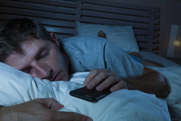 若者のライフ スタイル肖像疲れて眠っているまたはインターネットで夜遅くベッドにネットワークしながら眠りに落ちる男を疲れし ソーシャル メディア スマート携帯電話中毒の概念を過労 — ストック写真