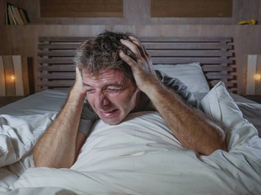dramatik ağlamak ve çığlık yatakta acı depresyon sorunu ve anksiyete krizi uyanık gece evde yatak çaresiz yatan genç çekici üzgün ve depresyonda adam portresi