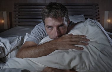 dramatik yatak duygu depresyon sorunu ve anksiyete krizi dalgın ve düşünceli acı endişeli Geceleri eve yatak uyanık yatan genç çekici üzgün ve depresyonda adam portresi