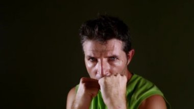 genç çekici ve şiddetli seyir spor adam eğitim gölge boks egzersiz ile saldırgan savaşçı egzersiz fitness yaşam tarzı koyu arka plan üzerinde izole çıplak knuckle
