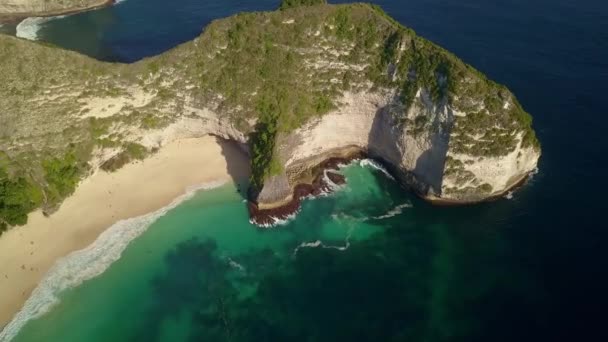 空中素晴らしい熱帯の楽園の白い砂のビーチ ドローンと停車し 美しいターコイズ ブルーの海の水の色とインドネシアのバリ島ヌサ ペニダ島で崖をロック — ストック動画