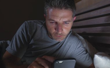 geç gece karanlık ışık cep telefonuyla internet bağımlılığı ve yaşam tarzı kavramı içinde sosyal medya online app zevk yatakta yatarken ağ ev yatak odası, genç çekici ve rahat adam