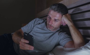 geç gece karanlık ışık cep telefonuyla internet bağımlılığı ve yaşam tarzı kavramı içinde sosyal medya online app zevk yatakta yatarken ağ ev yatak odası, genç çekici ve rahat adam
